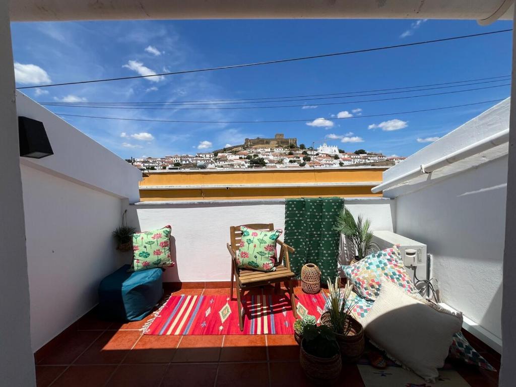 a balcony with a table and chairs on a roof at Casa Das Estrelas Vista Mertola Praia Fluvial in Mértola