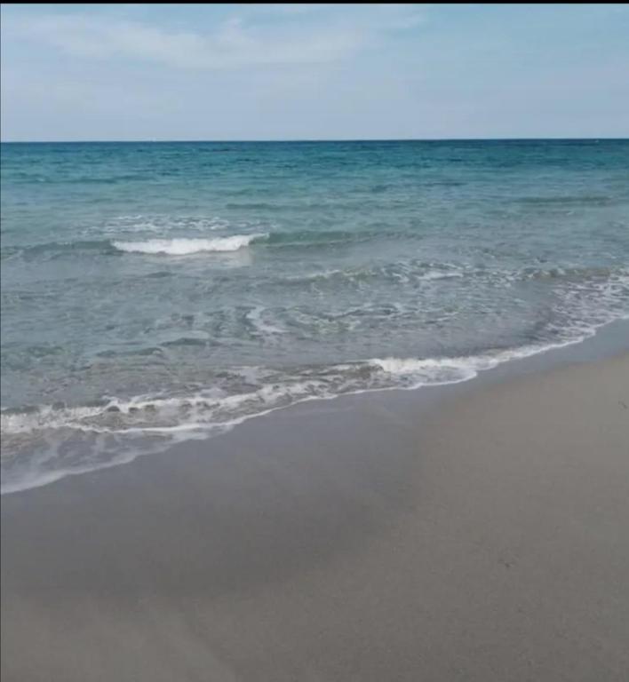 a beach with the ocean and the shoreline at Villa habiba 3 chambres in El Haouaria