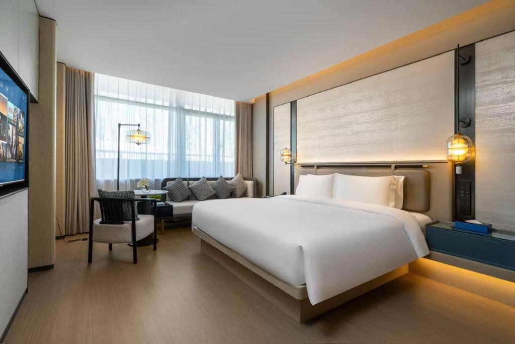 Postel nebo postele na pokoji v ubytování 上海虹桥荷逸唐酒店北新泾地铁站Shanghai Hongqiao Heyitang Hotel Beixinjing Subway Station Branch