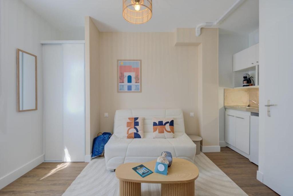 a living room with a white couch and a table at Le City - 800 m Gare - Hyper Centre - WiFi- Climatisé in Tours