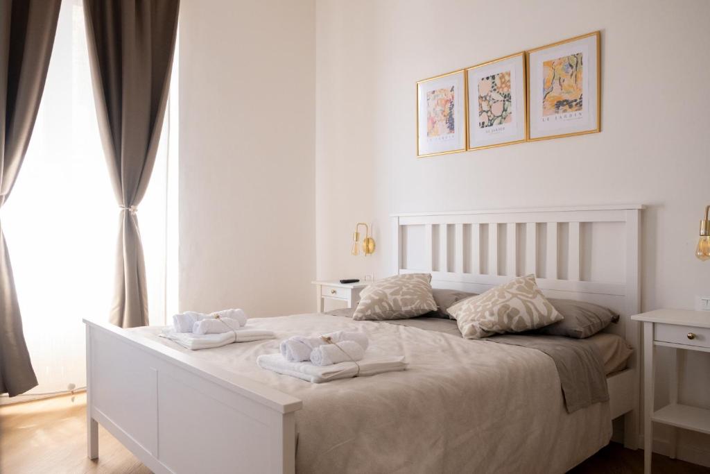 a white bedroom with two towels on a bed at Casamè Apartment Sulmona - a due passi da centro, free bike park in Sulmona