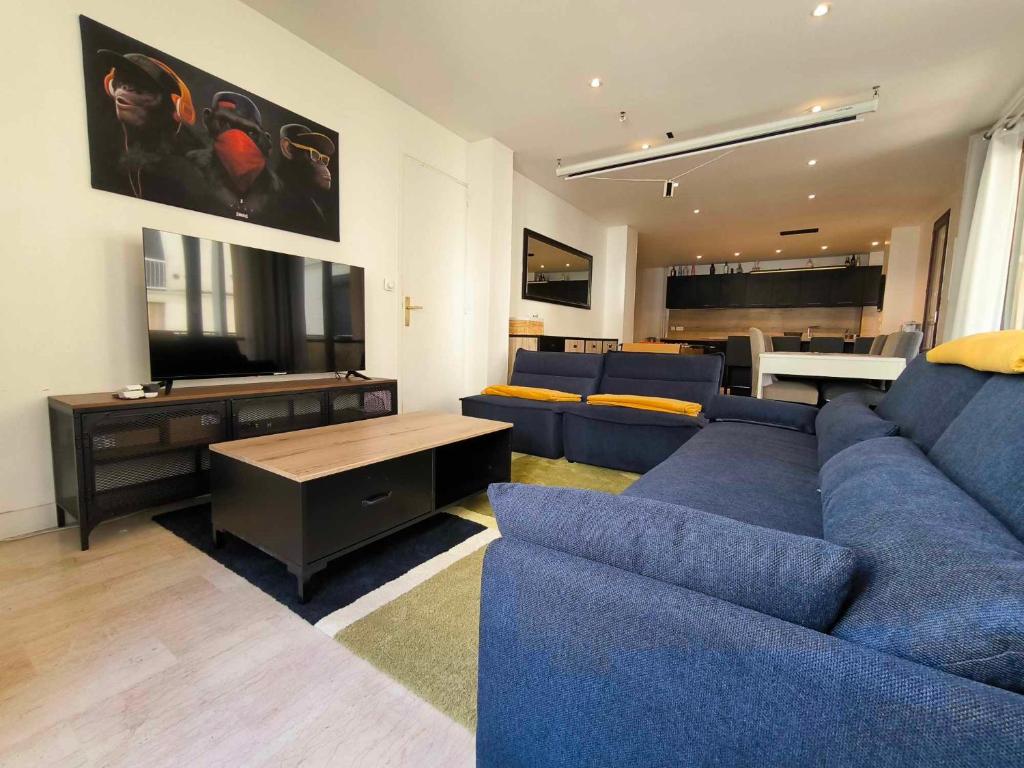 un salon avec un canapé bleu et une table dans l'établissement Appartement spacieux, parking, climatisation, rétroprojecteur, à Avignon