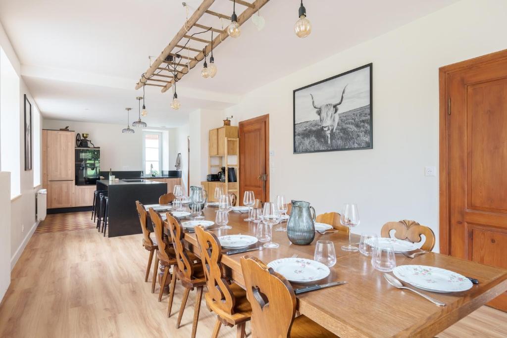 een eetkamer met een grote houten tafel en stoelen bij Gîte de l'Oriel - Gîte avec Grand Jardin in Sainte-Marie-aux-Mines