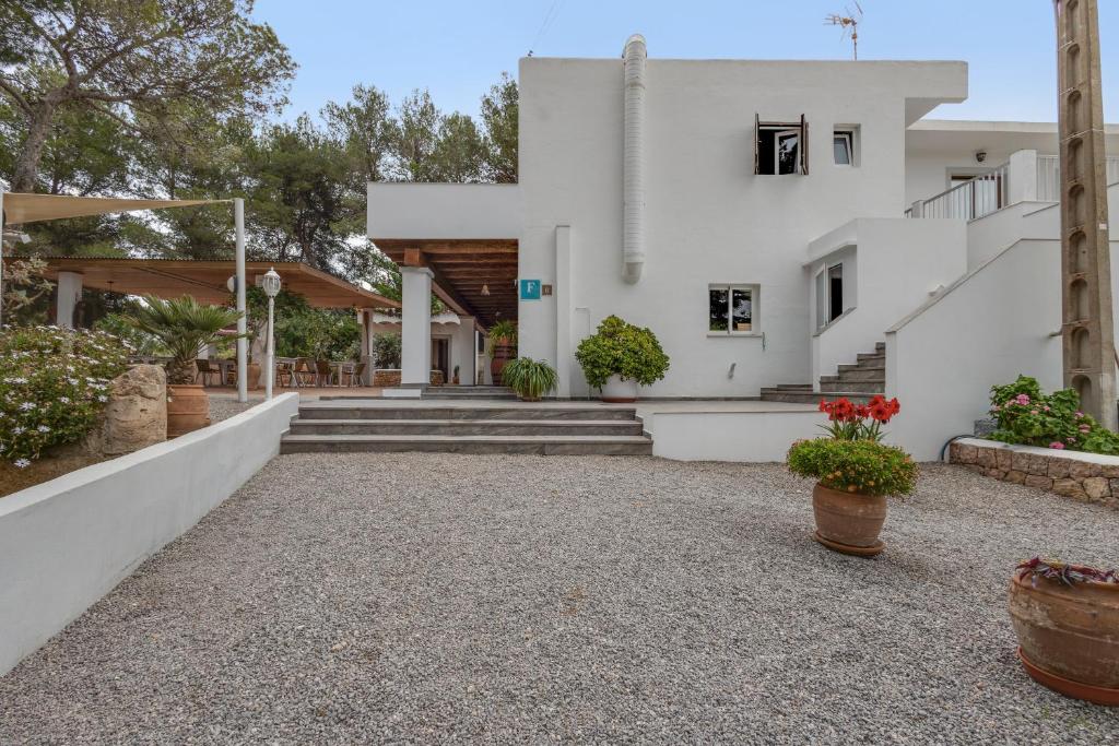 a white house with stairs and potted plants at Pensión las 3 Golondrinas in Santa Eularia des Riu