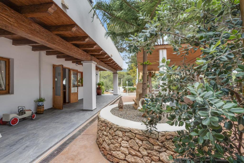 an internal courtyard of a house with a stone wall at Pensión las 3 Golondrinas in Santa Eularia des Riu