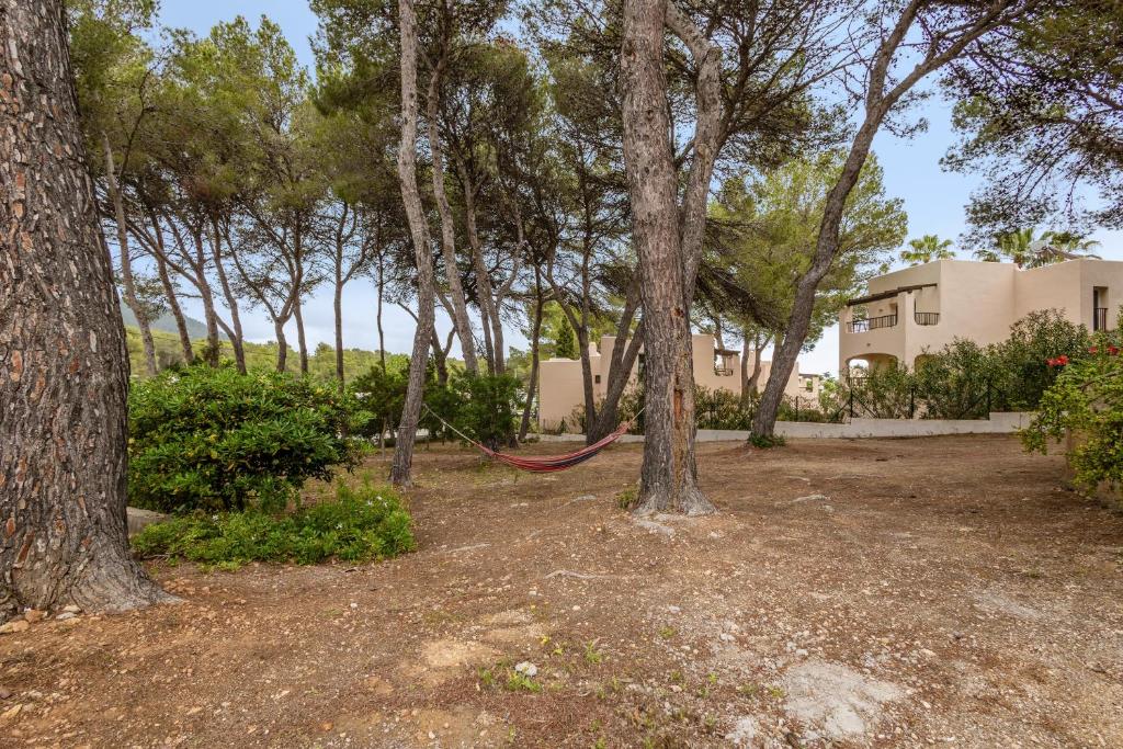 a hammock hanging between two trees in a yard at Pensión las 3 Golondrinas in Santa Eularia des Riu