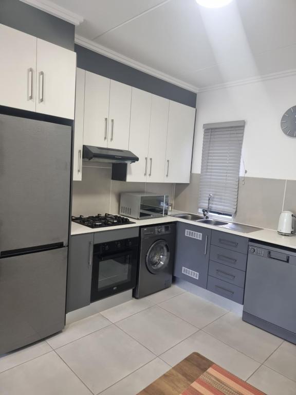 a kitchen with white cabinets and a dishwasher at paradise in Ballito in Ballito