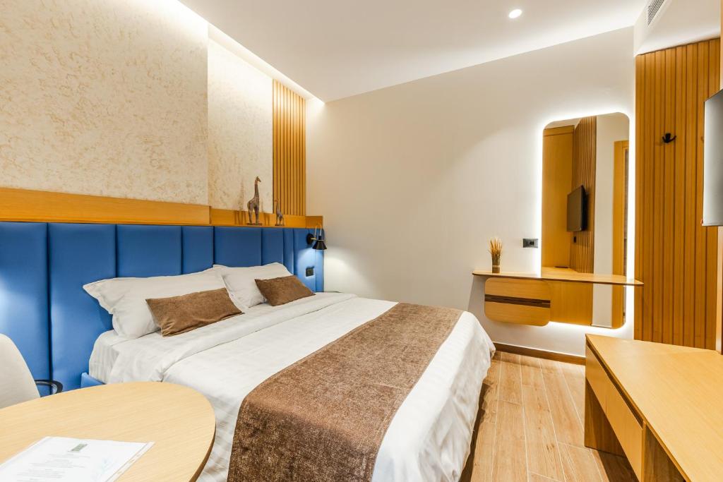 ドゥラスにあるArbo Boutique Hotelの大きなベッドとテーブルのある寝室