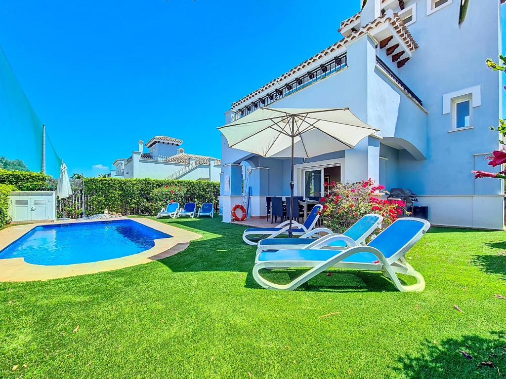 a yard with lounge chairs and a swimming pool at Mar Menor Golf Villa - 6310 in Torre-Pacheco
