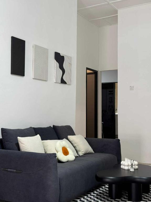 a living room with a blue couch with a stuffed animal at Kemaman AY Home in Cukai