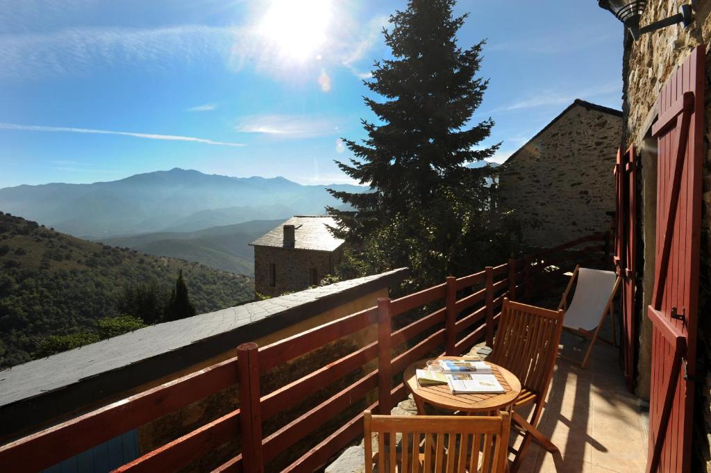 un tavolo e sedie su un balcone con vista di GITE MADRES- CORONAT BALCON du CANIGOU a Jujols