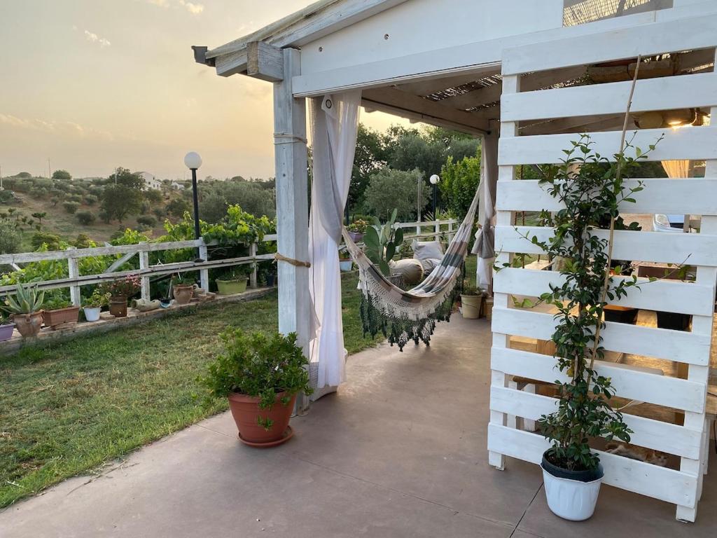 a porch with a hammock and potted plants at Villa Verde in Marconia