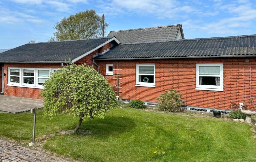 a red brick house with a tree in the yard at Gorgeous Home In Spøttrup With Wifi in Spottrup