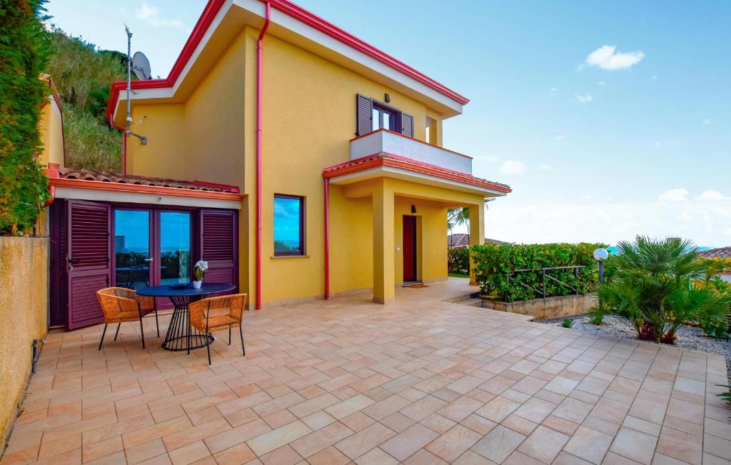 a house with a patio and a table at L'onda Dolce in Diamante