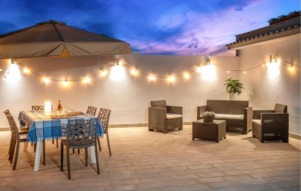 eine Terrasse mit Tisch, Stühlen und Lichtern in der Unterkunft Beautiful Apartment In Balestrate in Balestrate