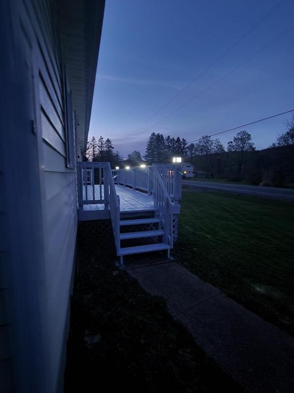 a porch of a house at night with lights at 2BR in Peaceful Country Near Ithaca in Willseyville