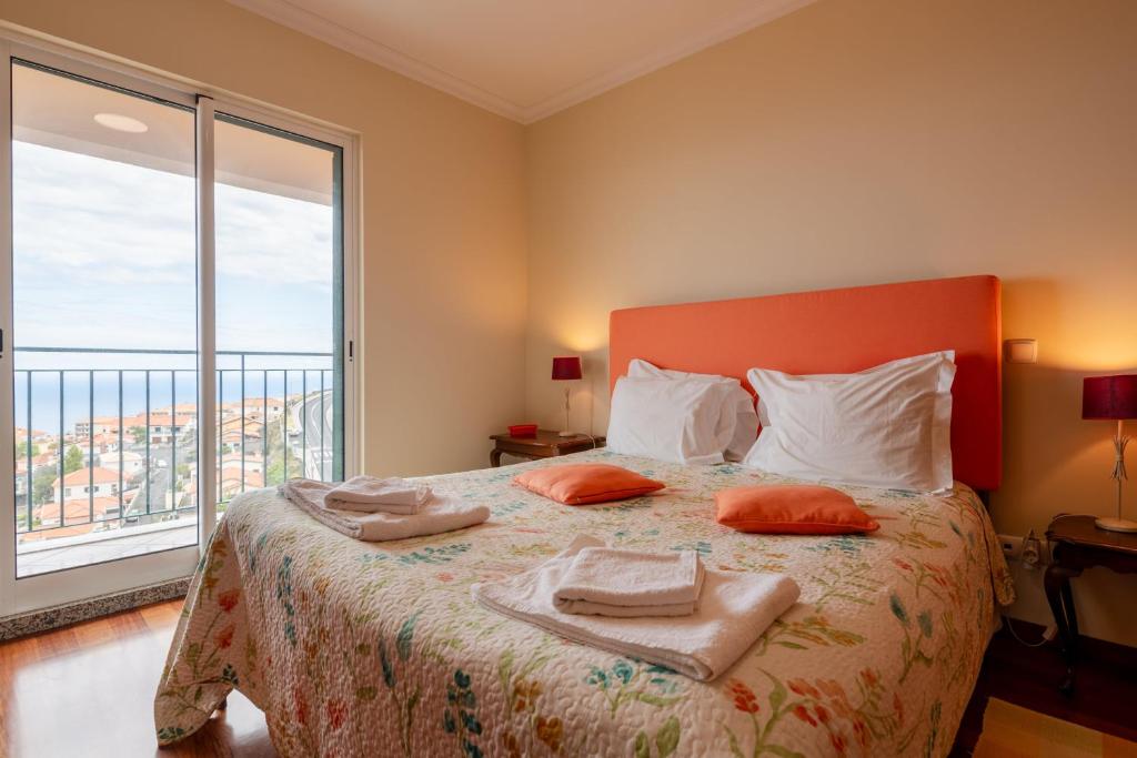 a bedroom with a bed with two towels on it at Caniço Quintas III by Trip2Portugal in Caniço