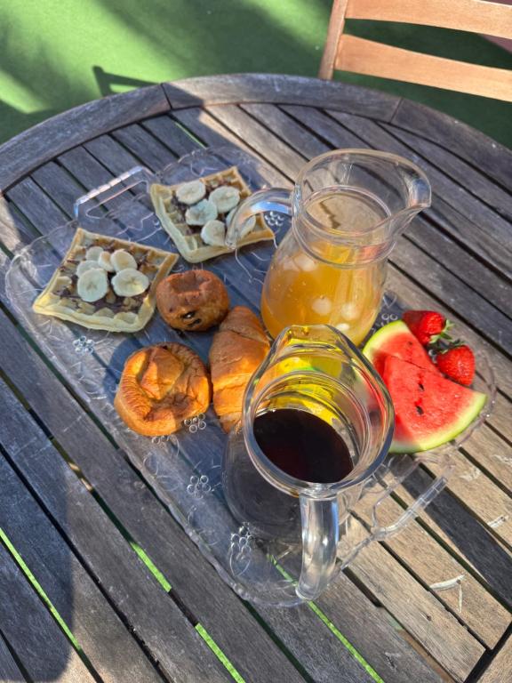 a plate of food with a drink and fruit on a table at Ti coin Charmant in Saint-Louis