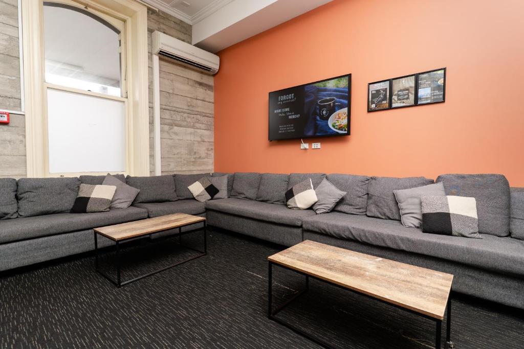 a living room with a couch and a tv at Haka House Auckland K'Road in Auckland