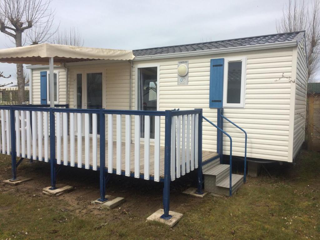 une petite maison blanche avec une balustrade bleue dans l'établissement le marais ile d'oleron, à Saint-Denis-dʼOléron
