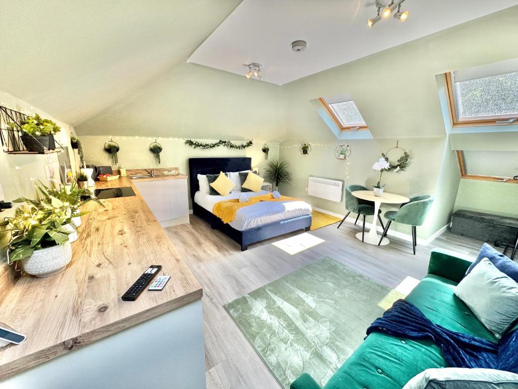a living room with a bed and a couch at Luxe Chic Retreat - Tropical Vibes & Skylight Serenity - WiFi - Large Smart TV - Minutes Walk to Town and Beach - Sleeps 3 in Bournemouth