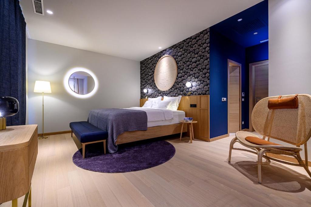 een hotelkamer met een bed en een stoel bij Villa Crystalsea 1 & 2 infinity heatedpool seaview in Hvar