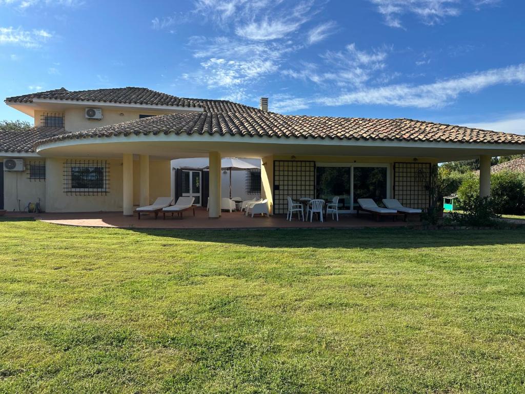 een huis met een patio en een grasveld bij Villa Degli Olivi in Pula