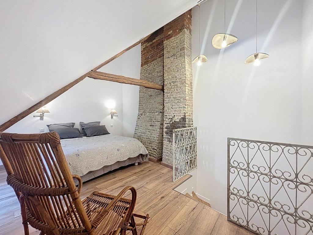 a bedroom with a bed and a chair in a room at Jolie maison Trouville sur Mer in Trouville-sur-Mer