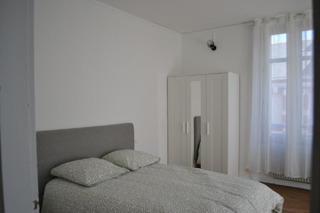 a bedroom with a bed with two pillows on it at Maison de ville 4 chambres à Cholet, Idéale pour les familles, groupes et sportifs ! in Cholet