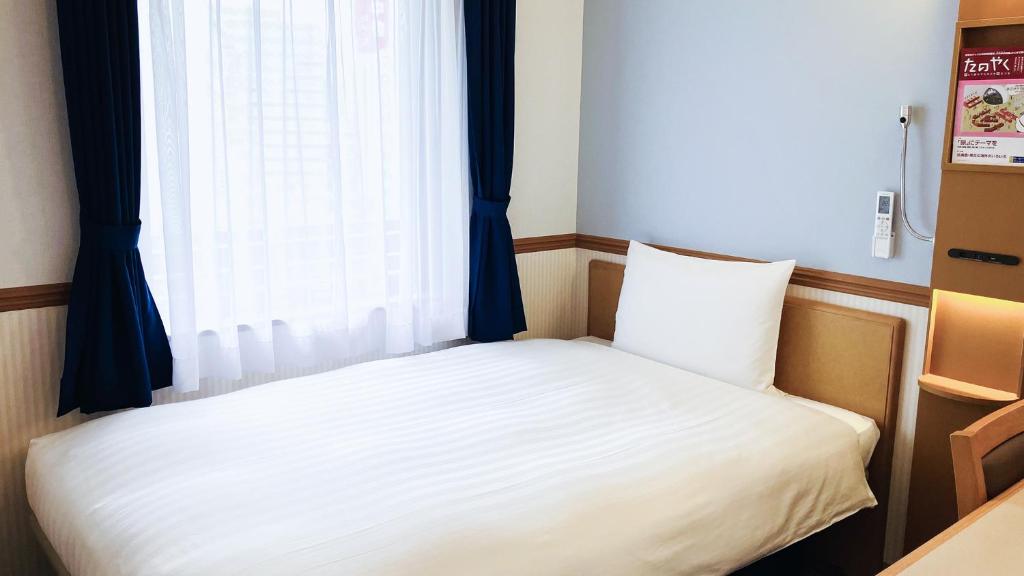 Postel nebo postele na pokoji v ubytování Toyoko Inn Nagoya-eki Shinkansen-guchi