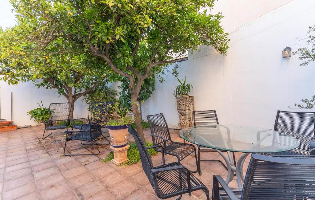 a patio with a table and chairs and trees at 3 Bedroom Nice Home In Cartagena in Cartagena