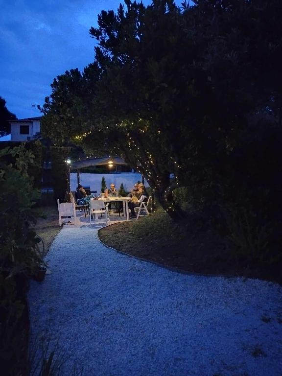 a group of people sitting at a table at night at Villa Anna Maria in Agia Paraskevi