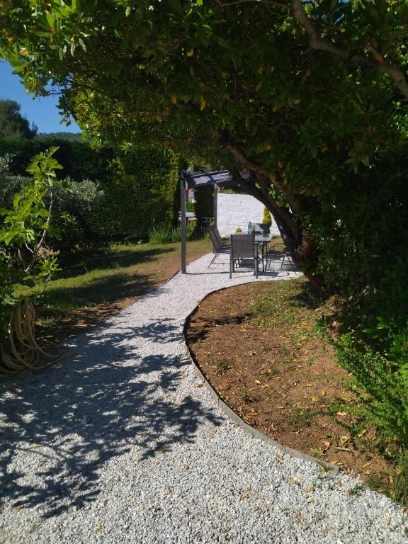 a walkway with a table and chairs in a park at Villa Anna Maria in Agia Paraskevi