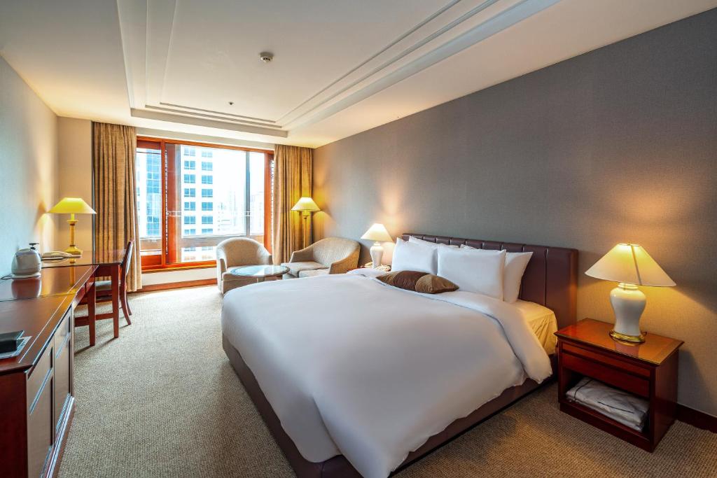 a hotel room with a large bed and a desk at Koreana Hotel in Seoul