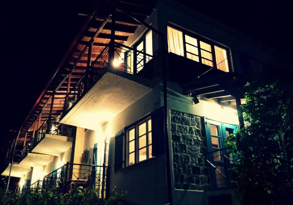 Aigaion Guesthouse في ثيرما: مبنى مضاء عليه سلالم في الليل