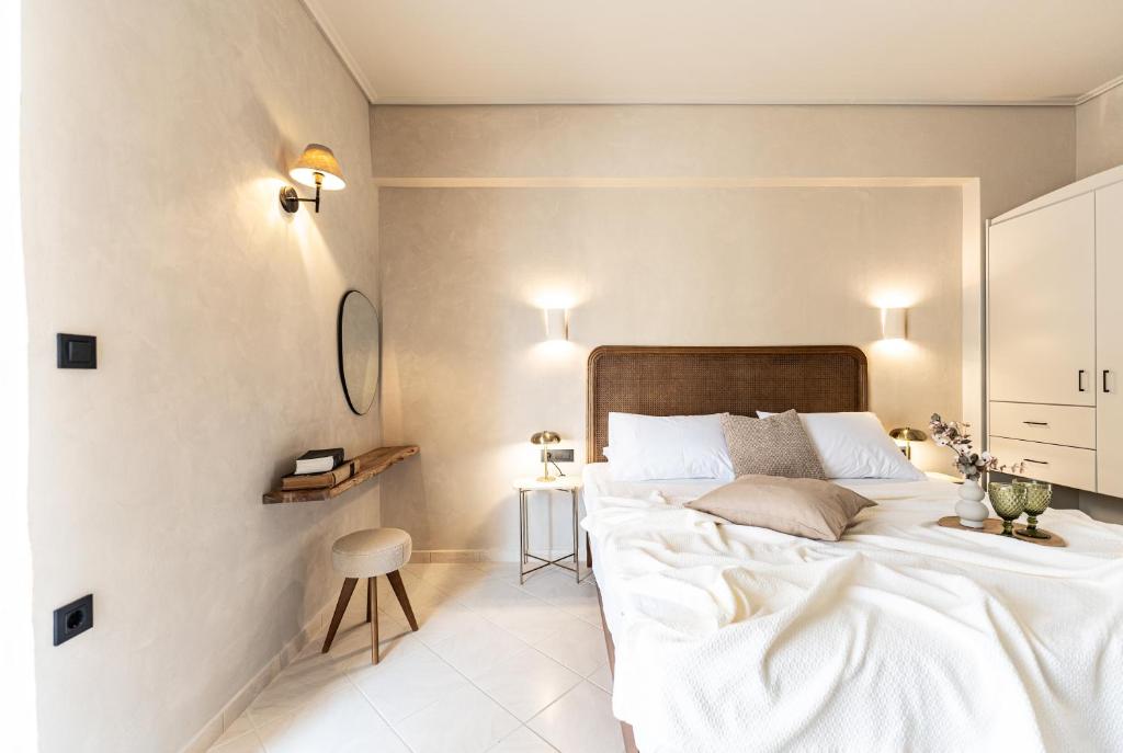 a bedroom with a large white bed and a stool at Joanna's Place in Palaiochora
