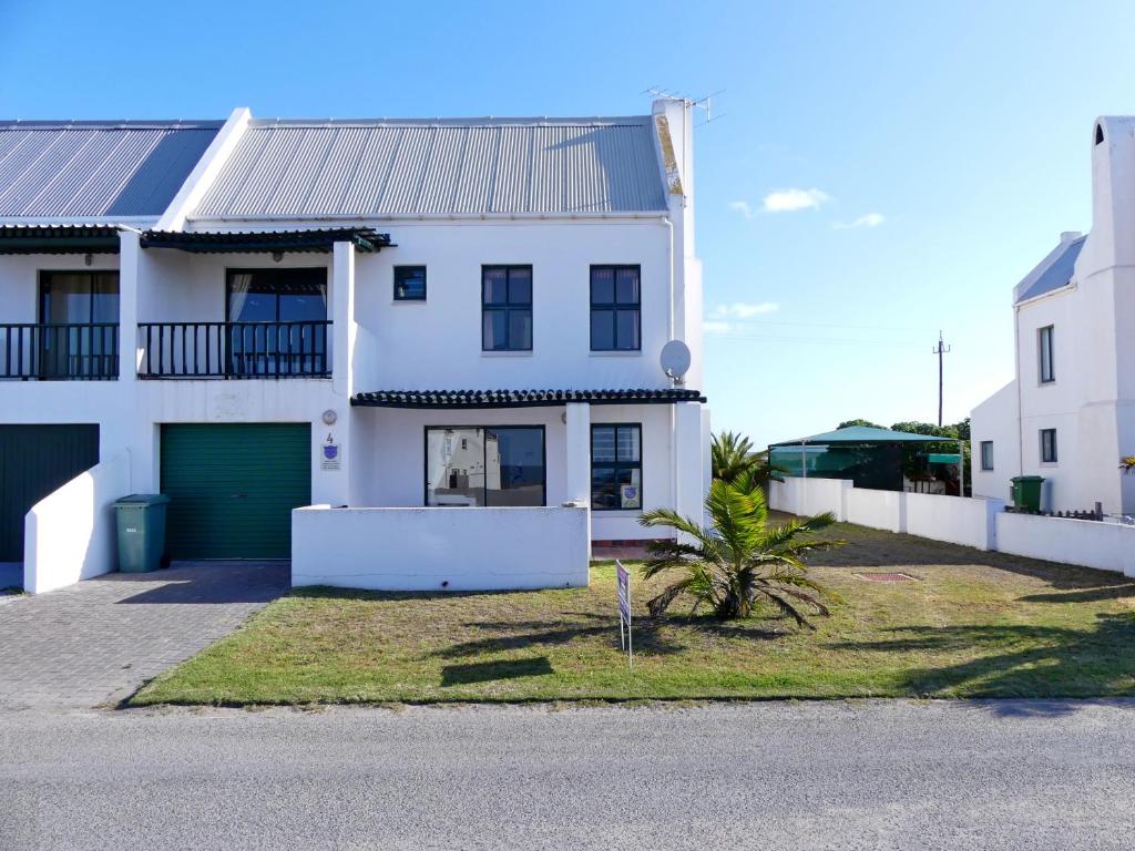 a white house with a green garage at Happy Wife in St. Helena Bay