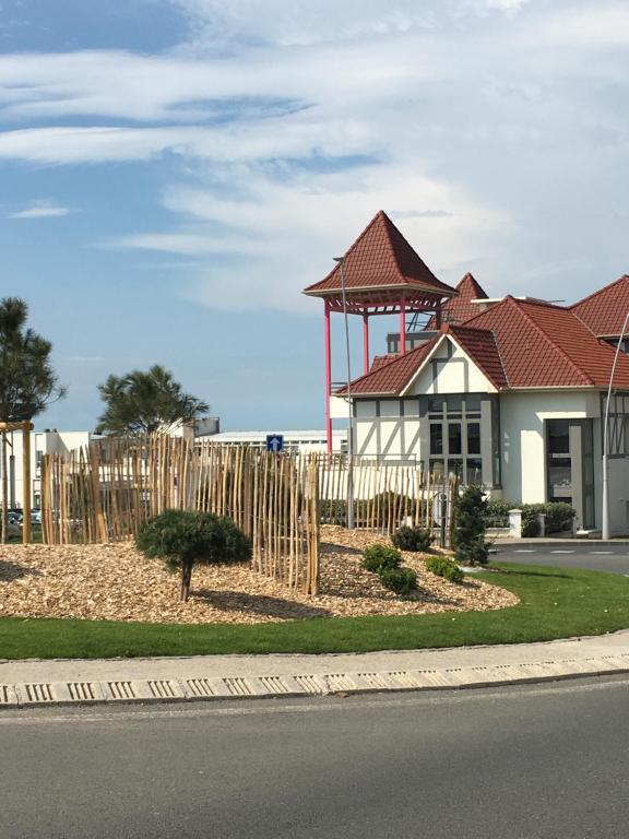 une clôture en bois devant un bâtiment dans l'établissement appartement proche de la plage , wimereux , 2 chambres , box stationnement , wifi, à Wimereux