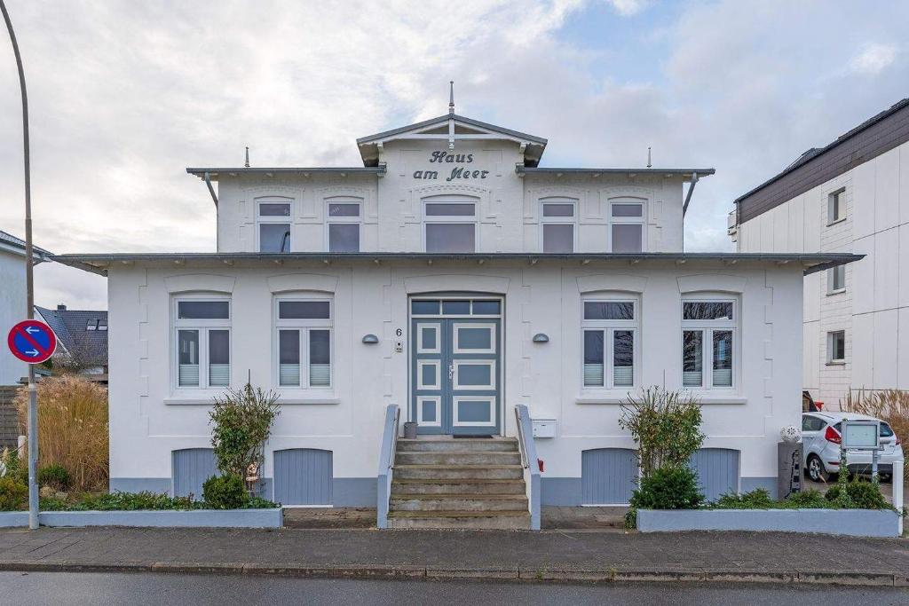 a white building with a sign on top of it at Haus am Meer- Traumhafter Meerblick in Dahme