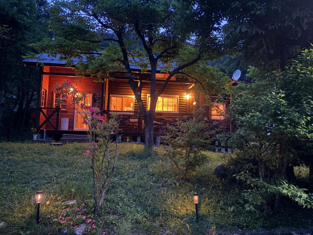 a cabin in the woods at night with lights at beau lac biwako annex in Takashima