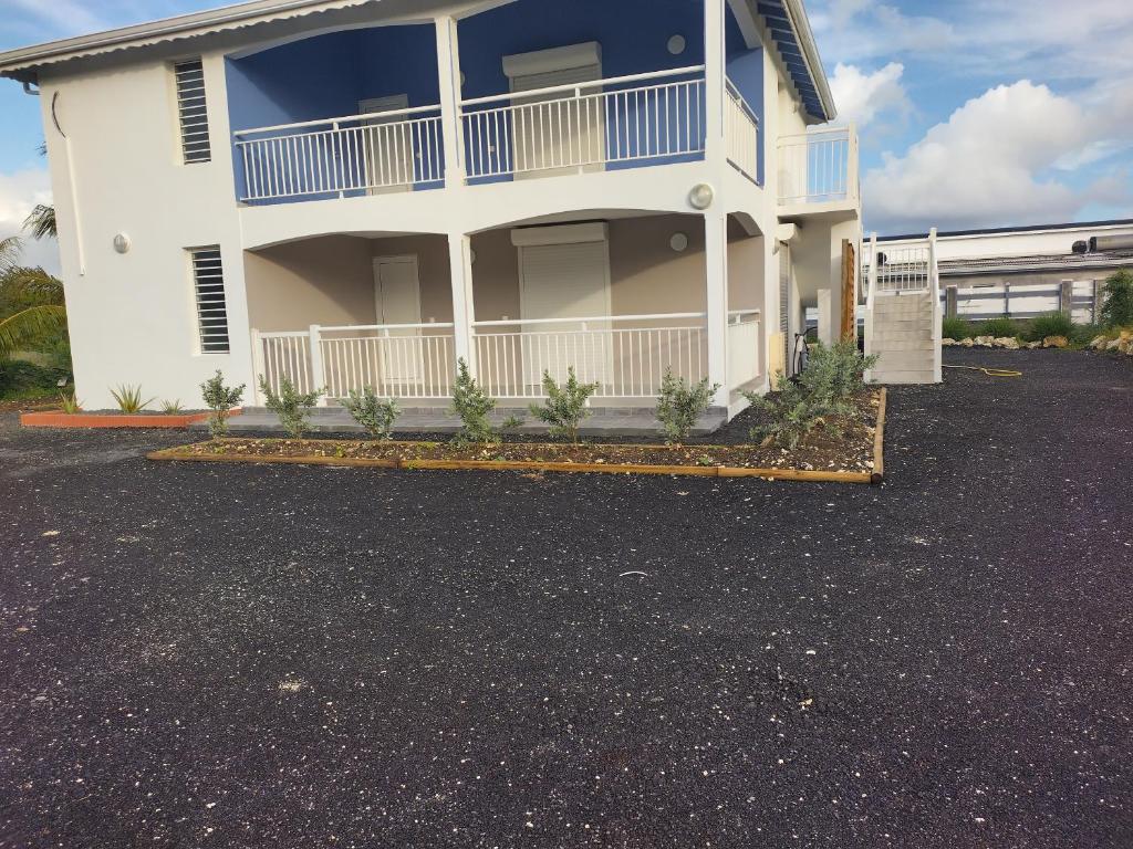 ein großes weißes Haus mit Parkplatz in der Unterkunft Pink des îles in Saint-François