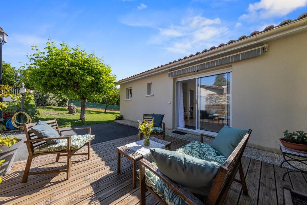 eine Terrasse mit Stühlen und einem Tisch auf einer Terrasse in der Unterkunft Au cœur des vignes in Montagne