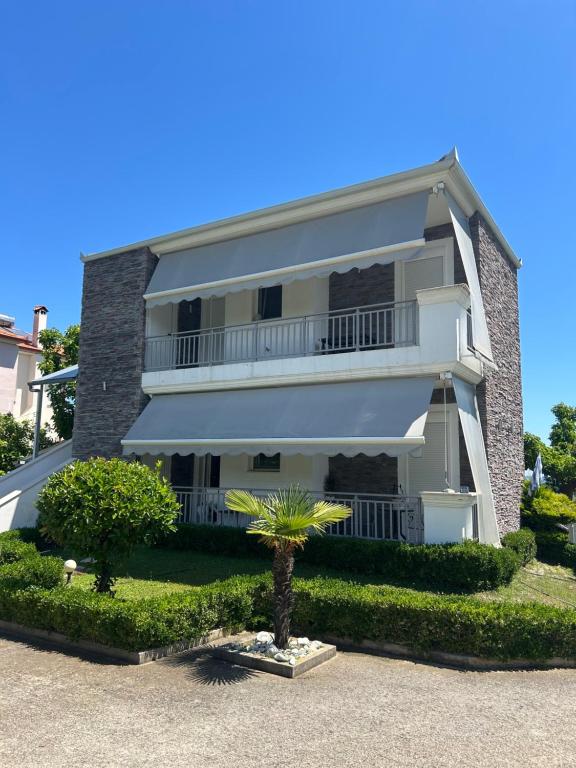 a building with a palm tree in front of it at Villa Anastasia in Leptokaria
