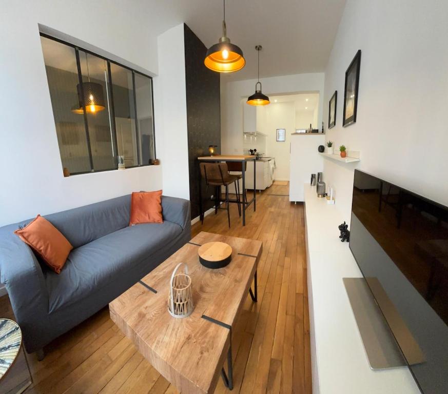 - un salon avec un canapé bleu et une table en bois dans l'établissement Le Saint André Hyper centre ville, à Saint-Quentin