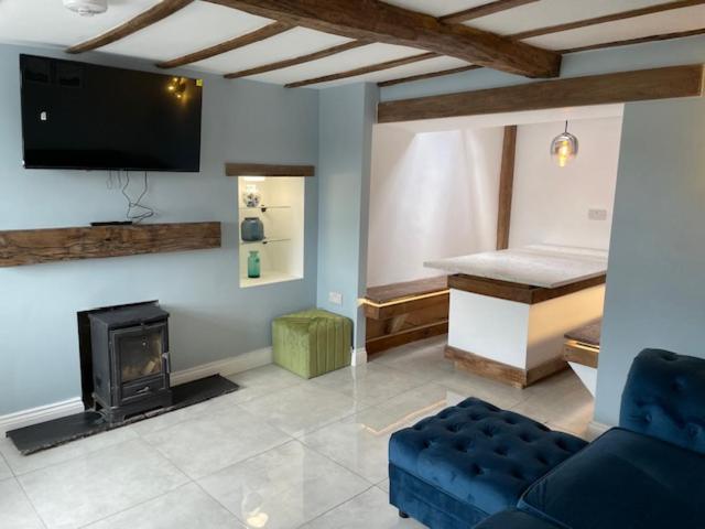 a living room with a couch and a fireplace at Brock cottage Tideswell newly modernised in heart of Peak District National Park in Tideswell