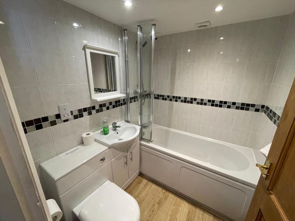 a bathroom with a toilet and a tub and a sink at No 3 Mill Cote Cottage in Kingsbridge