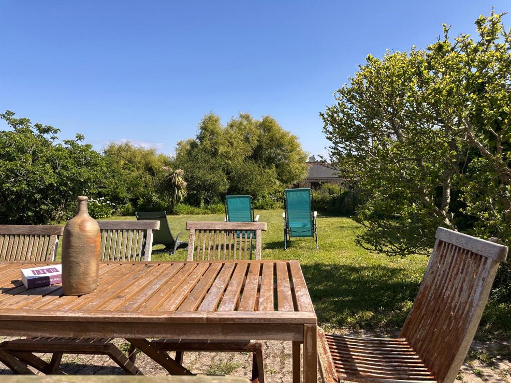 - une table de pique-nique en bois avec 2 chaises et un vase dans l'établissement Maison Bretonne rénovée - Plages et centre à pied, à Camaret-sur-Mer