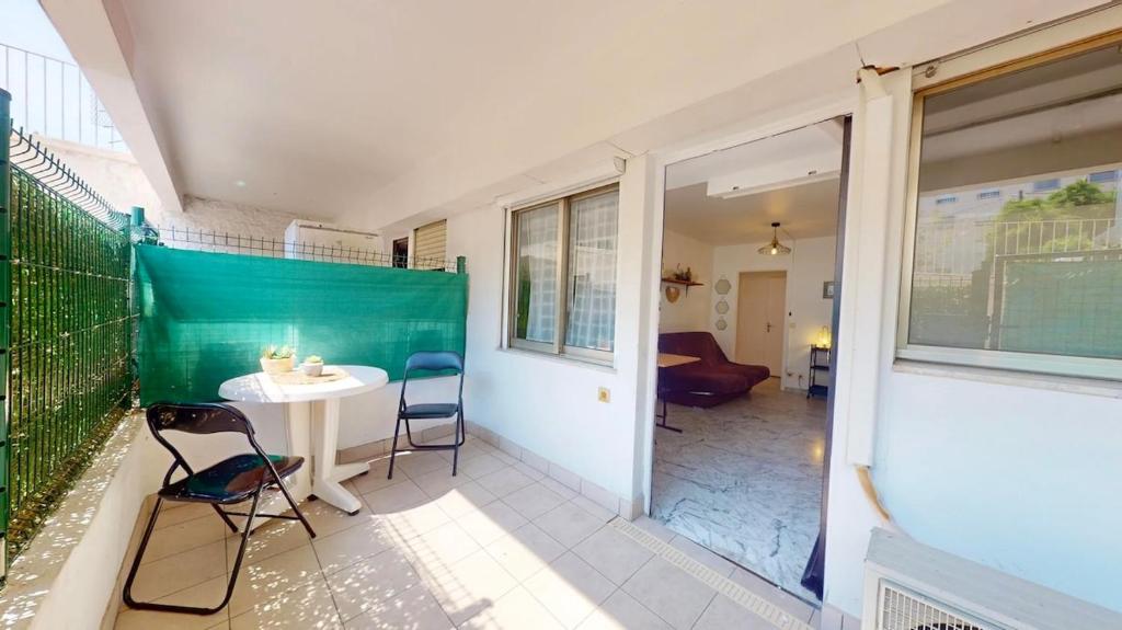 Cette chambre dispose d'un balcon avec une table et des chaises. dans l'établissement Cosy studio near beaches, à Nice