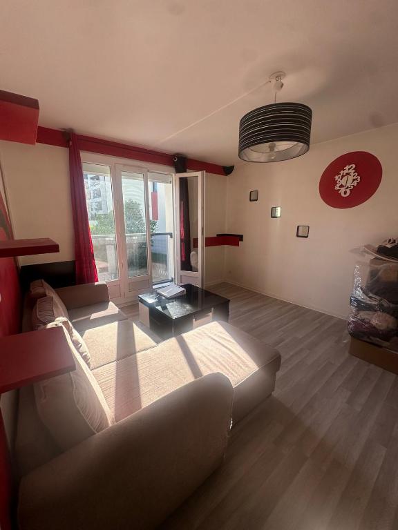 una sala de estar con un sofá y una mesa en Joli T2 proche de la gare, en Clermont-Ferrand