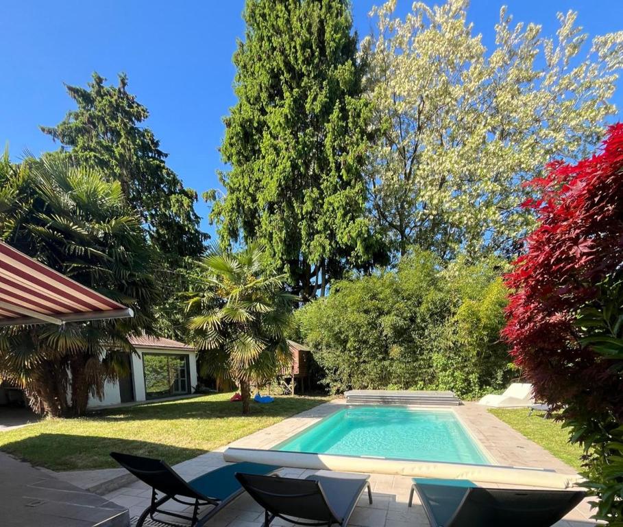- une piscine dans une cour avec des chaises et des arbres dans l'établissement Villa Vergers Disneyland BMYGUEST, à Serris